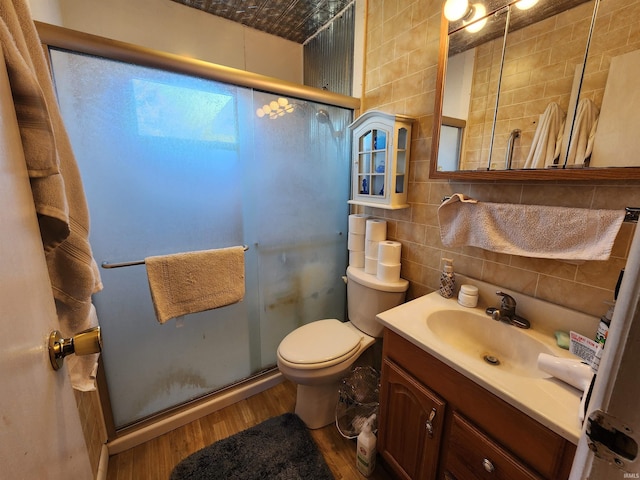 full bath featuring decorative backsplash, a stall shower, tile walls, and wood finished floors