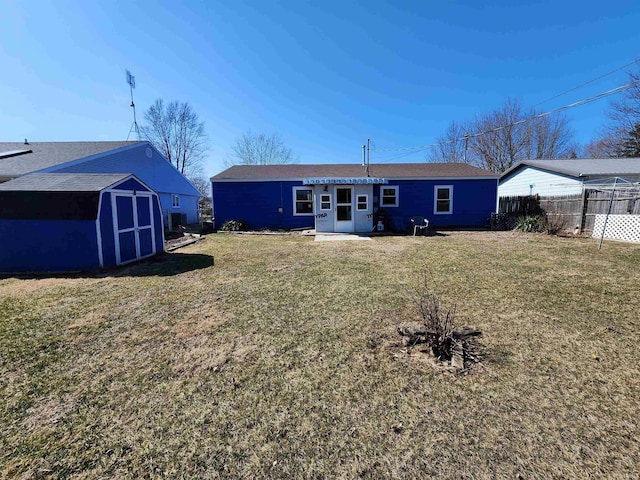 rear view of property featuring an outbuilding, a storage shed, a yard, and fence