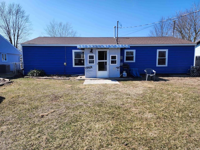 back of property featuring a yard, central AC, and fence