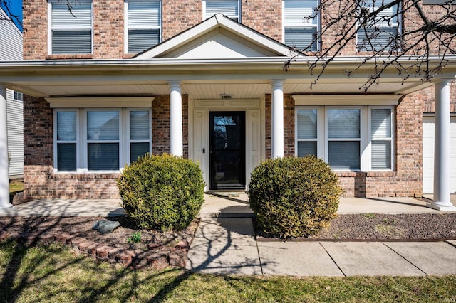 property entrance featuring brick siding and a porch