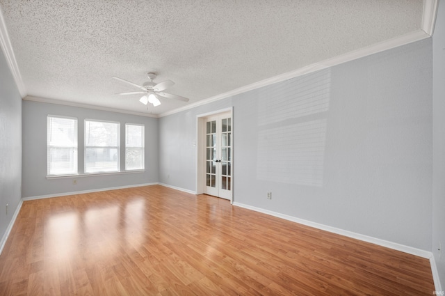 empty room with a ceiling fan, light wood finished floors, french doors, a textured ceiling, and crown molding