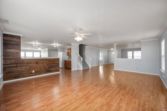 unfurnished living room featuring light wood finished floors, visible vents, a textured ceiling, and ceiling fan