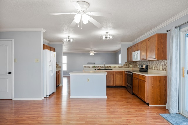 kitchen featuring ceiling fan with notable chandelier, plenty of natural light, white appliances, light wood finished floors, and light countertops