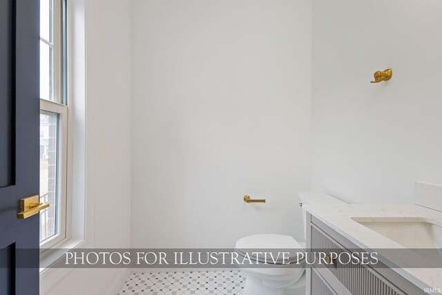 bathroom with plenty of natural light, toilet, and vanity