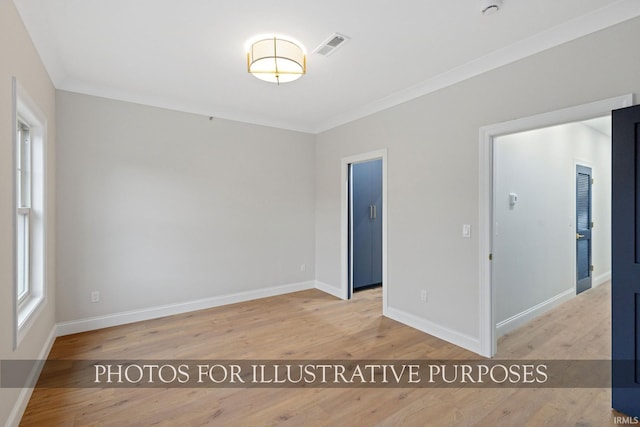 unfurnished room with visible vents, baseboards, light wood-style flooring, and crown molding