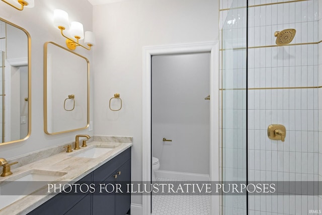 full bathroom featuring double vanity, toilet, tiled shower, and a sink