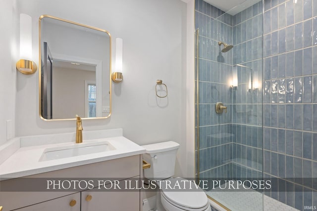 full bath featuring vanity, toilet, and tiled shower