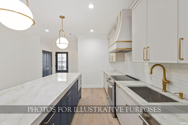 kitchen featuring light wood-type flooring, stainless steel range with electric stovetop, custom range hood, a sink, and tasteful backsplash