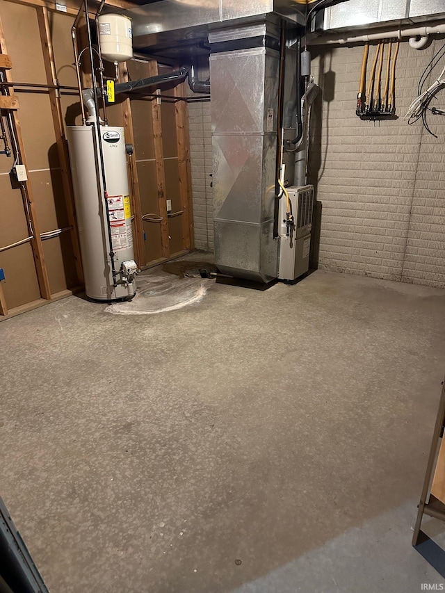 unfinished basement featuring heating unit, gas water heater, and brick wall