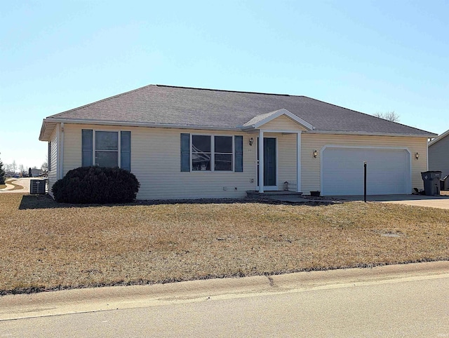 single story home with an attached garage, concrete driveway, a front lawn, and a shingled roof