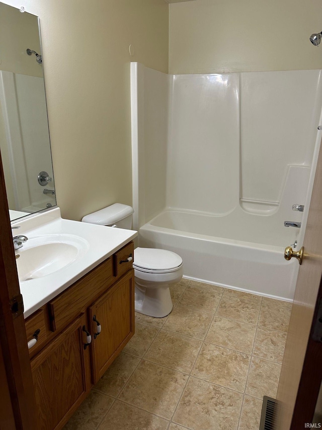 bathroom featuring bathing tub / shower combination, toilet, vanity, and tile patterned flooring