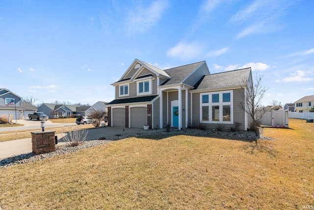 traditional-style home with a front lawn, an attached garage, a residential view, and driveway