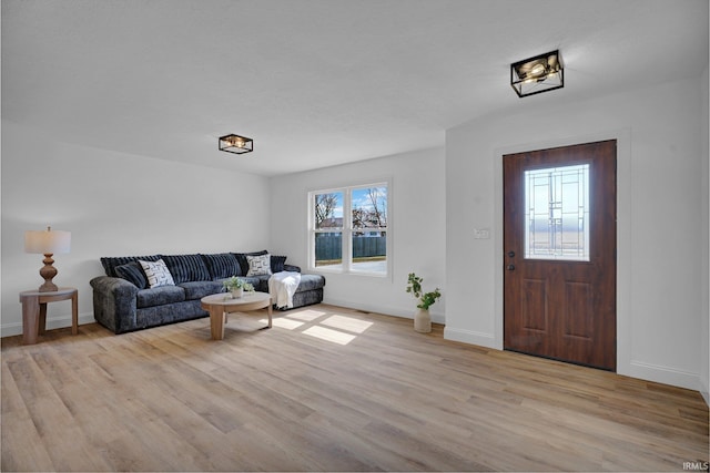 living room featuring baseboards and light wood finished floors