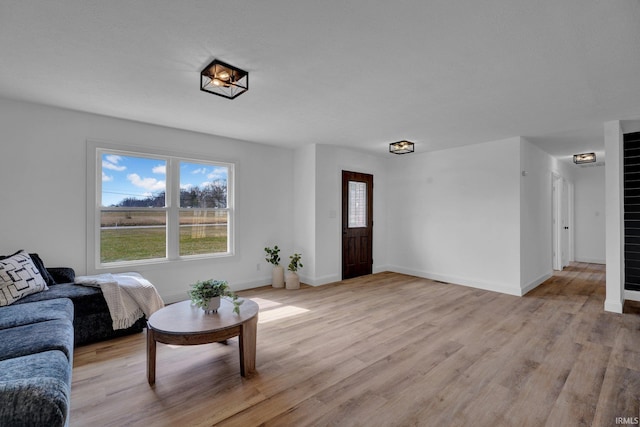 living room with baseboards and light wood-style floors