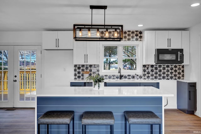 kitchen with a healthy amount of sunlight, french doors, black microwave, and a sink