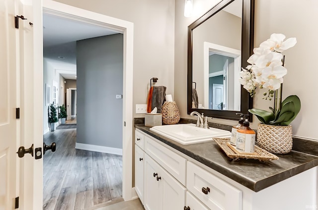 bathroom featuring vanity, baseboards, and wood finished floors