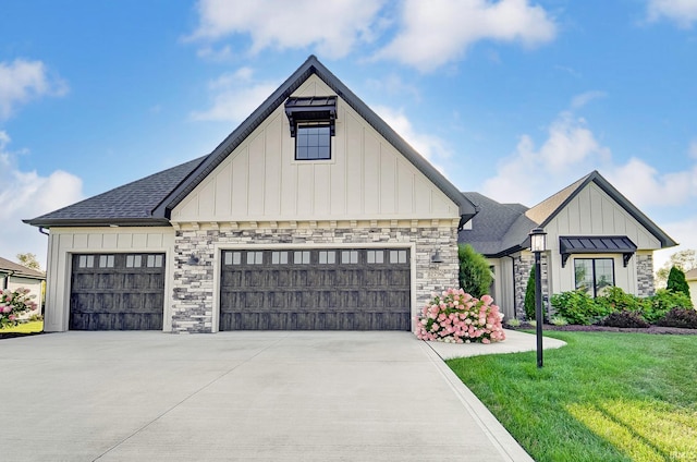 modern farmhouse featuring stone siding, concrete driveway, and an attached garage