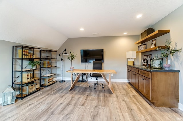 office featuring baseboards, light wood finished floors, recessed lighting, a sink, and vaulted ceiling