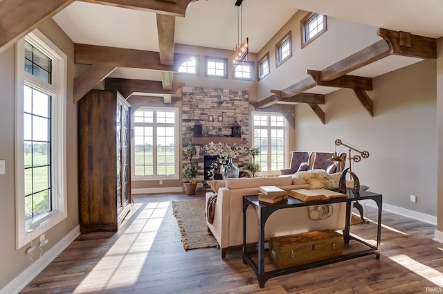 living area featuring beamed ceiling, baseboards, a stone fireplace, and hardwood / wood-style flooring