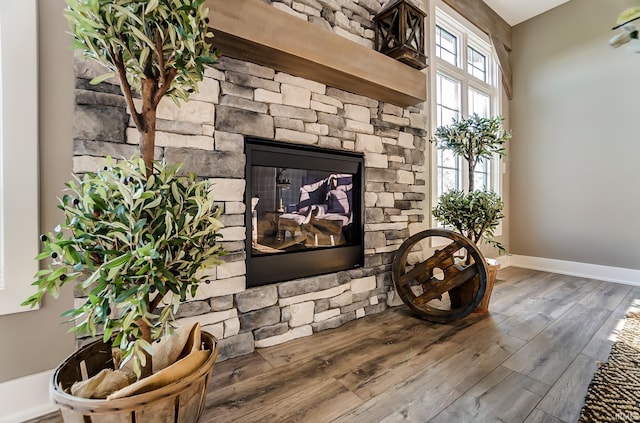 interior details with a fireplace, wood finished floors, and baseboards