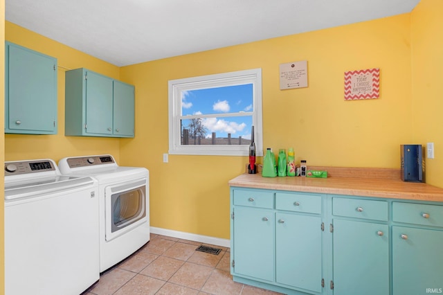 laundry area featuring visible vents, baseboards, light tile patterned floors, washer and dryer, and cabinet space