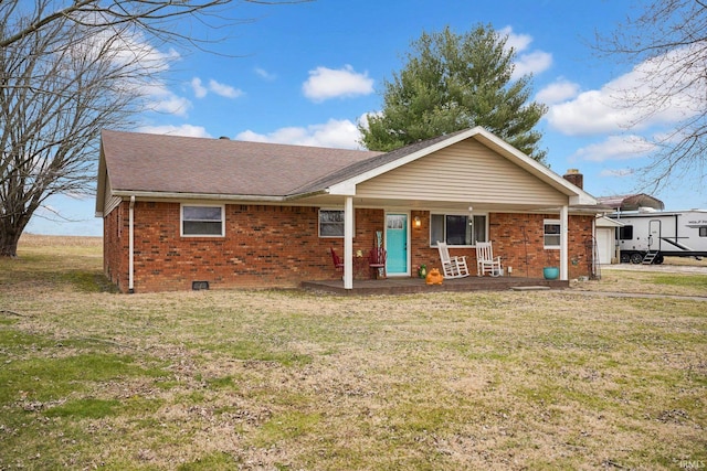 view of front facade with crawl space, brick siding, covered porch, and a front yard