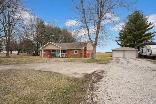 view of front of house featuring brick siding, a detached garage, a front lawn, a porch, and an outdoor structure