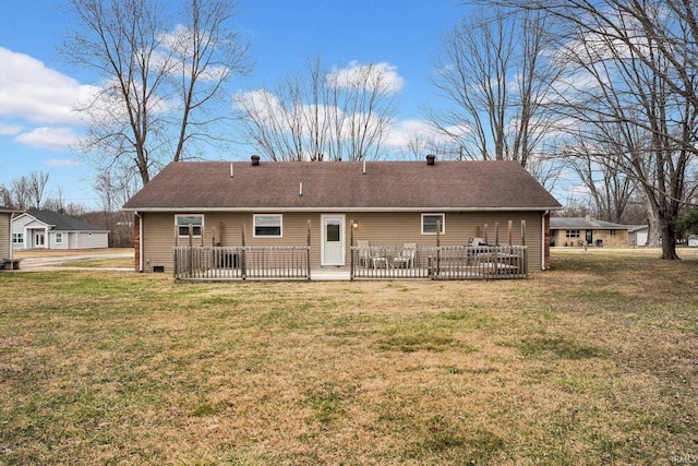 rear view of property with a lawn and roof with shingles