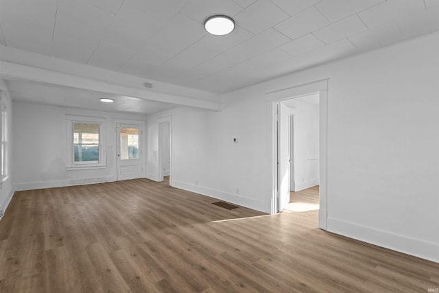 spare room featuring visible vents, baseboards, and wood finished floors