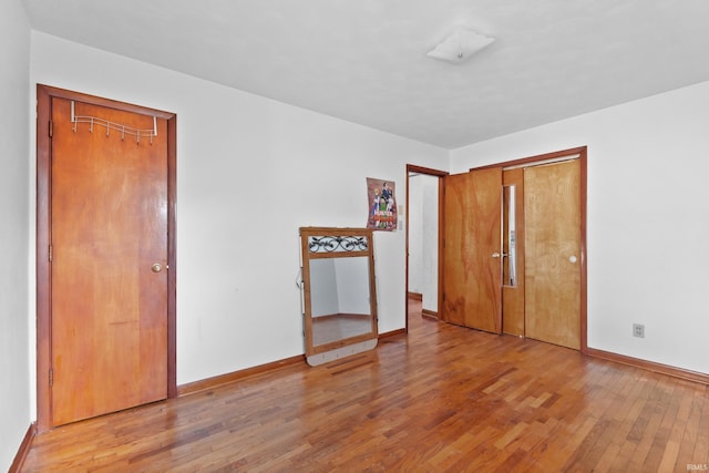 unfurnished bedroom with light wood-style flooring and baseboards