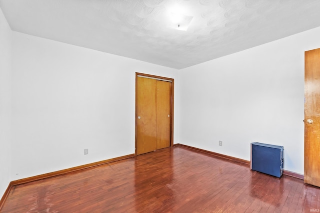 spare room featuring baseboards and hardwood / wood-style floors