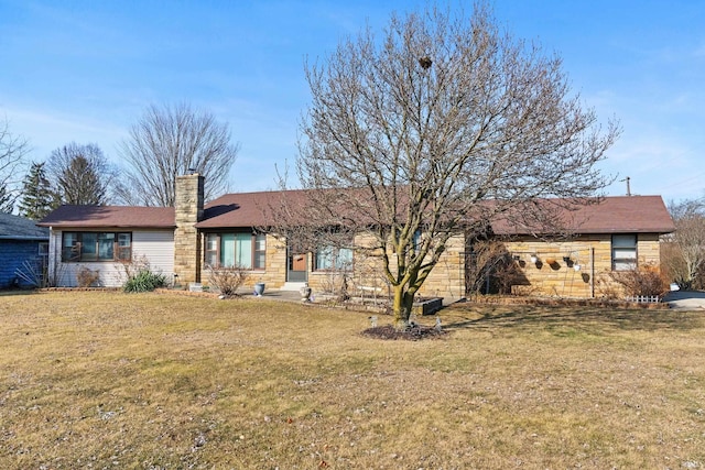 rear view of property with a lawn, stone siding, and a chimney