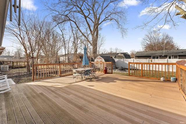 wooden deck with outdoor dining area and fence