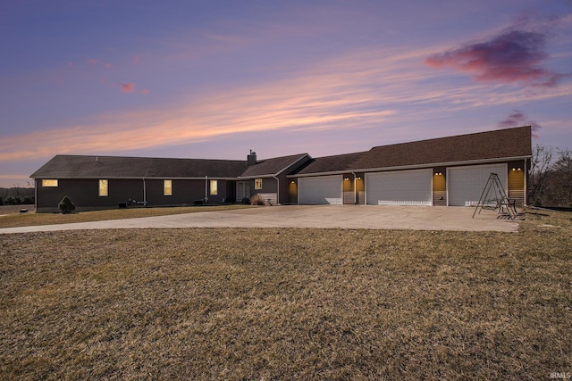 single story home with a garage, driveway, a chimney, and a front yard