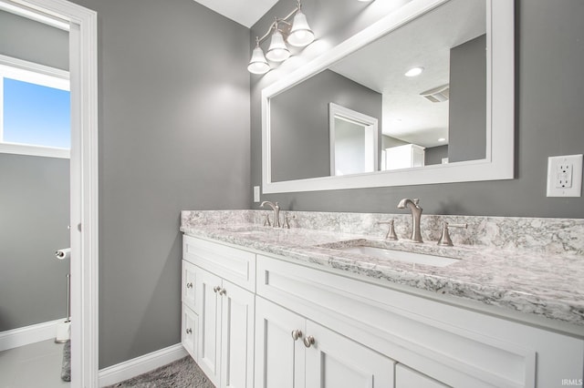 full bathroom featuring double vanity, visible vents, baseboards, and a sink