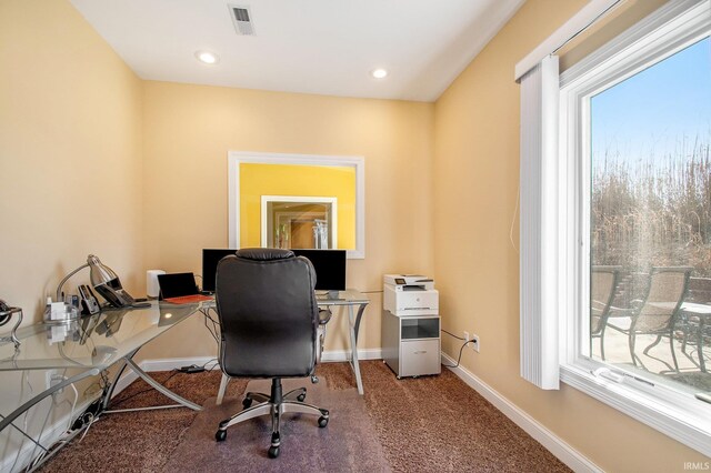 office featuring visible vents, carpet flooring, a healthy amount of sunlight, and baseboards