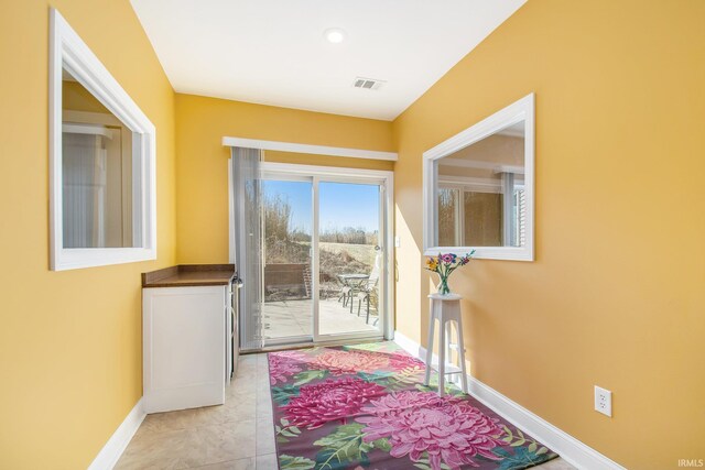 doorway to outside featuring light tile patterned floors, visible vents, and baseboards