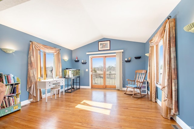 living area featuring vaulted ceiling, wood finished floors, and baseboards