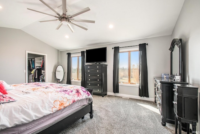 bedroom featuring a walk in closet, baseboards, light colored carpet, vaulted ceiling, and a closet