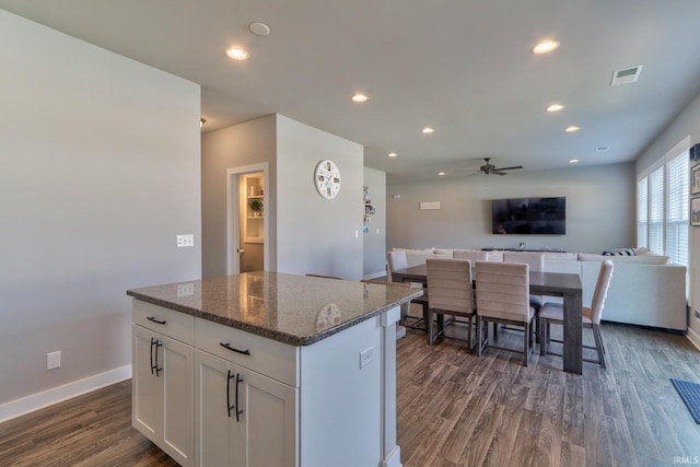 kitchen with a kitchen island, dark wood finished floors, open floor plan, recessed lighting, and white cabinetry