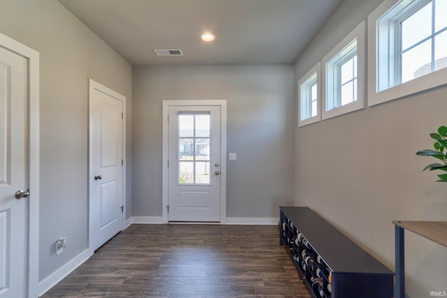 doorway featuring visible vents, plenty of natural light, baseboards, and dark wood-style flooring