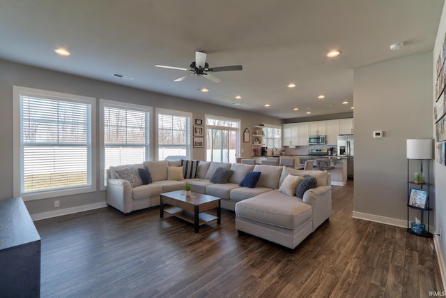 living room featuring visible vents, baseboards, recessed lighting, dark wood-style flooring, and ceiling fan