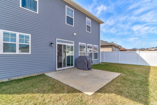 back of property with a lawn, a patio, and fence