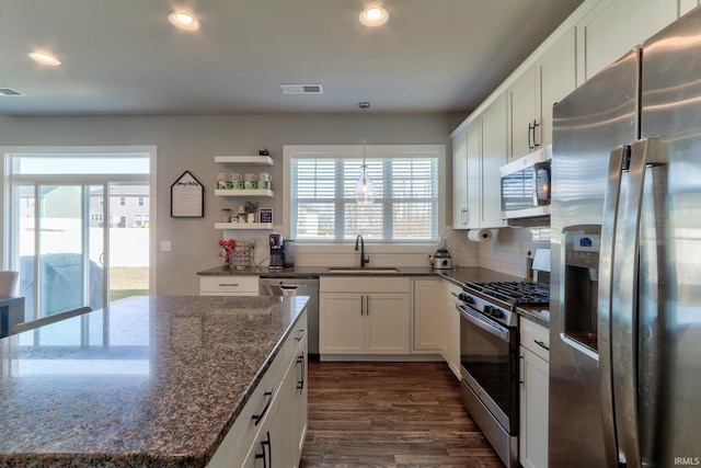 kitchen with visible vents, dark wood-type flooring, white cabinets, stainless steel appliances, and a sink