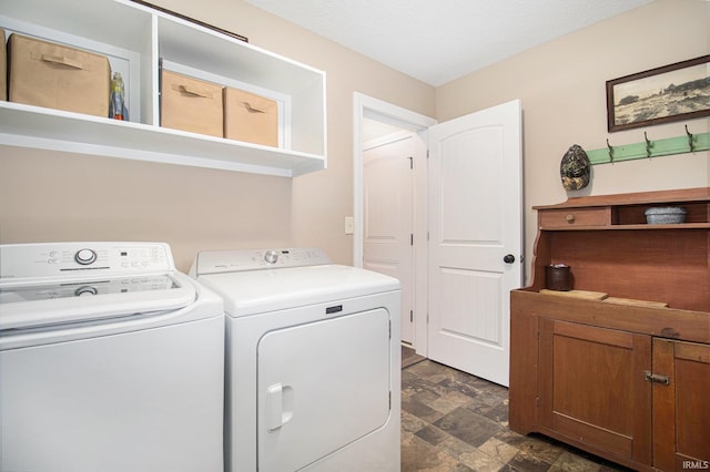 washroom featuring washer and clothes dryer and stone finish floor