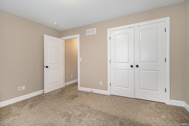 unfurnished bedroom featuring a closet, visible vents, baseboards, and carpet