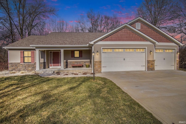 craftsman-style house with a yard, stone siding, a porch, and concrete driveway