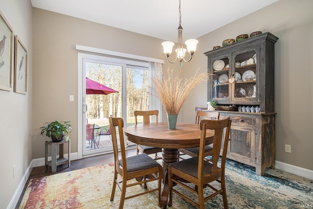 dining room featuring baseboards, an inviting chandelier, and wood finished floors