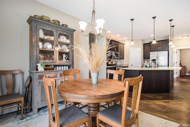 dining room with dark wood finished floors, a chandelier, and recessed lighting