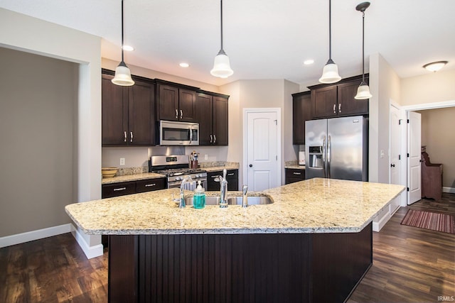 kitchen with dark brown cabinets, baseboards, appliances with stainless steel finishes, dark wood-style floors, and a sink